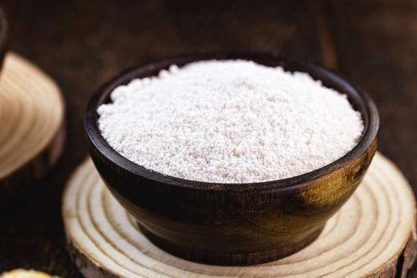 tigela de madeira com tapioca. Também chamado Goma, é o amido extraído da mandioca, geralmente preparado em forma granulada.
. - Foto, Imagem