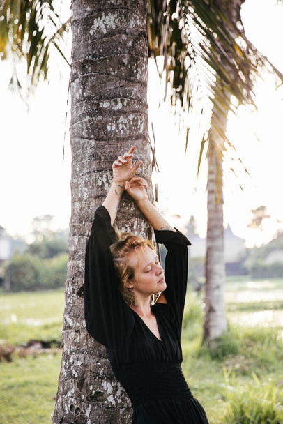 blonde blogger girl doing yoga and meditation in a rice field while traveling in Indonesia to Bali - Foto, immagini