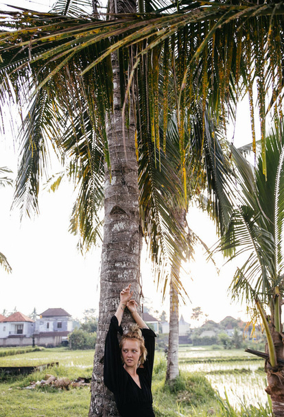 blonde blogger girl doing yoga and meditation in a rice field while traveling in Indonesia to Bali - Fotografie, Obrázek