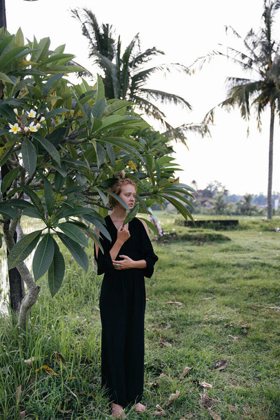 blonde blogger girl doing yoga and meditation in a rice field while traveling in Indonesia to Bali - Zdjęcie, obraz