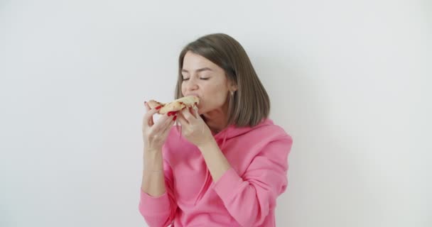 młoda kobieta jedząca pizzę - Materiał filmowy, wideo