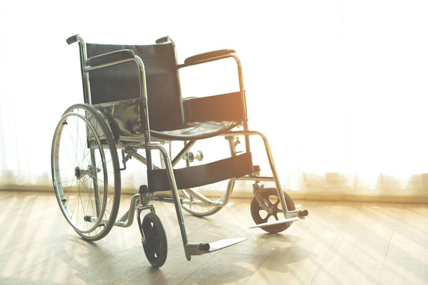 部屋の病院で窓の背景による朝の太陽と車椅子。車椅子は患者サービスを待っています。右側にコピースペースがあります. - 写真・画像
