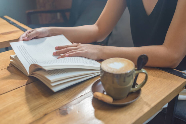 Junge Frau gibt Buch im Café ab - Foto, Bild