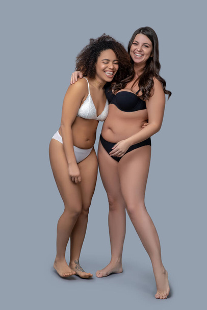 Two young adult women standing in underwear. - Фото, изображение