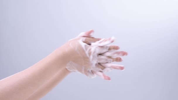 Handinstructies wassen. Aziatische jonge vrouw met behulp van vloeibare zeep om handen te wassen, concept van hygiëne om te stoppen met het verspreiden van coronavirus geïsoleerd op grijze witte achtergrond, real time, close-up. - Video
