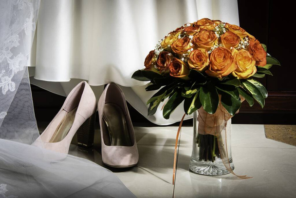 Un beau cliché de sandales roses, robe blanche et un bouquet de fleurs roses
 - Photo, image
