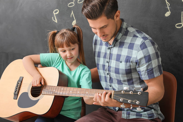 Вчитель дає уроки музики в школі
 - Фото, зображення