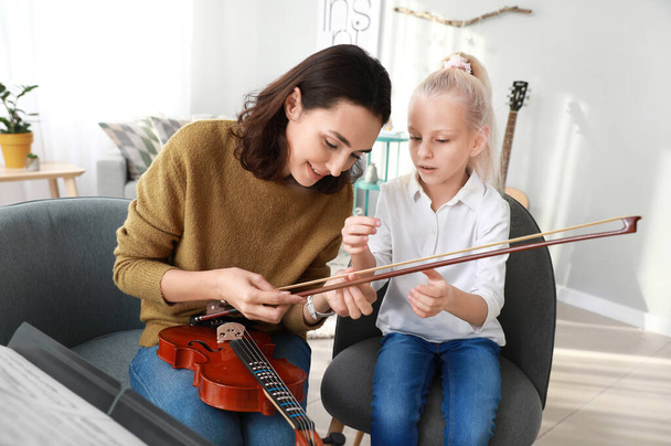 Private music teacher giving violin lessons to little girl at home - Photo, Image