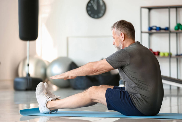 Sporty elderly man training in gym - Photo, Image