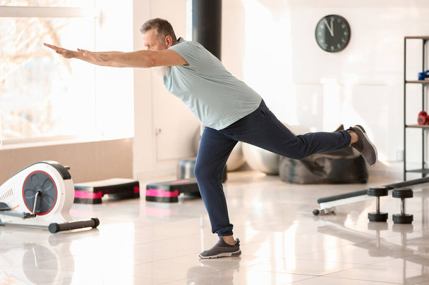 Sporty elderly man training in gym - Valokuva, kuva