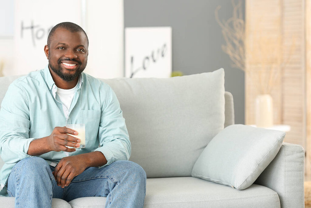 Uomo afro-americano che beve latte a casa
 - Foto, immagini