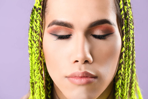 Portrait of young transgender woman on color background, closeup - Photo, image