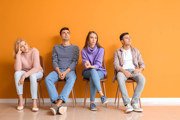 Mladí lidé čekají ve frontě u barevné stěny - Fotografie, Obrázek