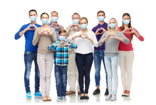 people in medical masks making hand heart gesture - Valokuva, kuva