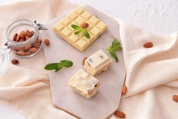 Makea valkoinen suklaa pähkinöillä ja mintulla pöydällä
 - Valokuva, kuva