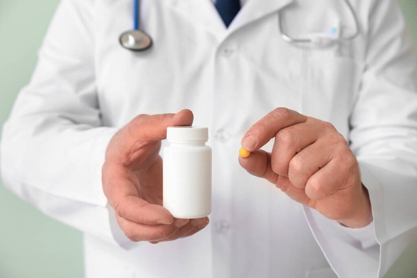 Senior doctor with pills on color background, closeup - Zdjęcie, obraz