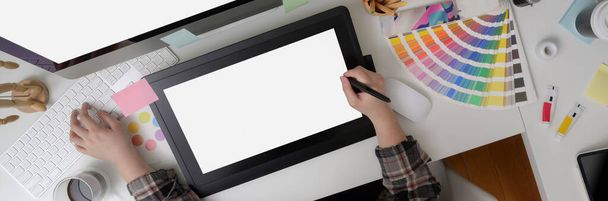 Bovenaanzicht van vrouwelijke grafisch ontwerper tekening op mock-up grafische tablet, computer en designer benodigdheden op witte tafel  - Foto, afbeelding