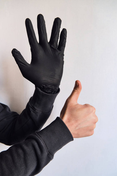 Man hands in black medical gloves closeup. Protecting the body from viruses and bacteria. Hand hygiene, sterile uniform. The fight against epidemic. Safety for your life. Prevention and control. Stop coronavirus - Photo, image