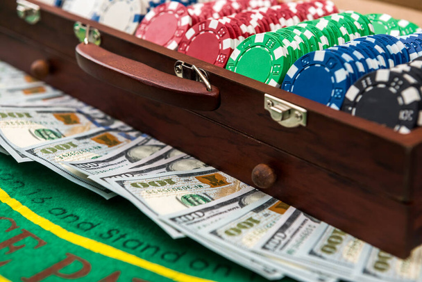 Pokerchips und Dollars in einem Fall auf dem Spieltisch. - Foto, Bild
