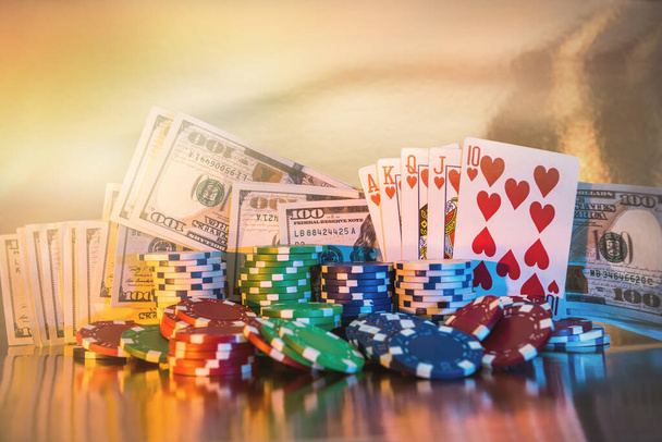 Poker concept - chips, playing card and us money on golden background. - Photo, Image