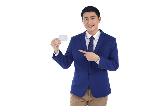 Asian handsome young business man holding a credit or debit card, isolated on white background - Foto, imagen