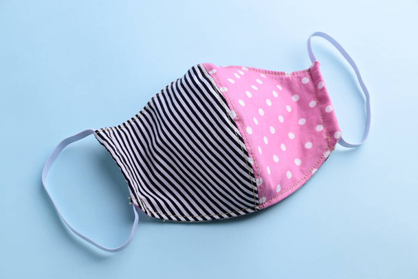 black and pink fashion face mask handmade from fabric cloth on blue background - Foto, Bild