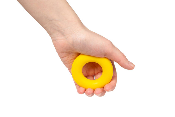 Žlutý a oranžový expandér v ruce ženy izolované na bílém pozadí. Horní pohled.  - Fotografie, Obrázek