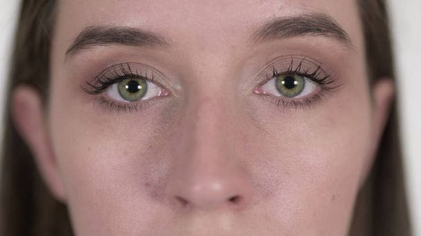 Nahaufnahme der blinkenden Augen einer jungen Frau - Foto, Bild