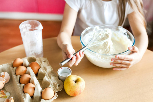 Girl prepare Breakfast, baking, stir in a bowl of flour, milk, eggs, pancakes, children help mother, family Breakfast, cooking - Valokuva, kuva