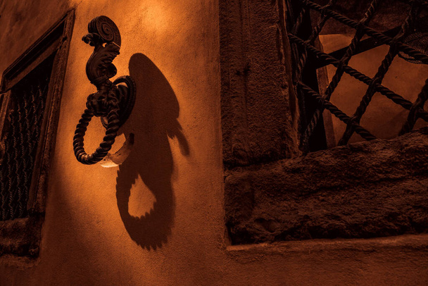 Door knocker on the wall with lights and shadows - Photo, Image