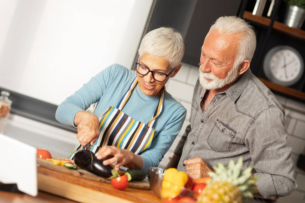 Senior couple using digital tablet in kitchen - Zdjęcie, obraz