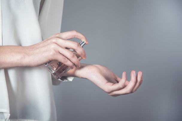 nő kéz parfüm palack a kézben - Fotó, kép