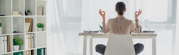 plano panorámico de mujer de negocios meditando en pose de loto con gyan mudra en el lugar de trabajo con varilla de incienso
 - Foto, Imagen
