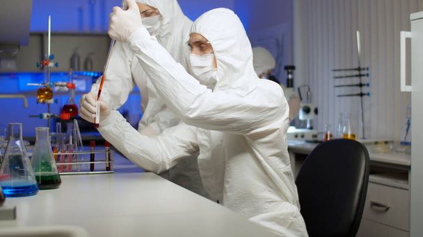 実験室でウイルスのサンプルを調べる生物学者 - 写真・画像