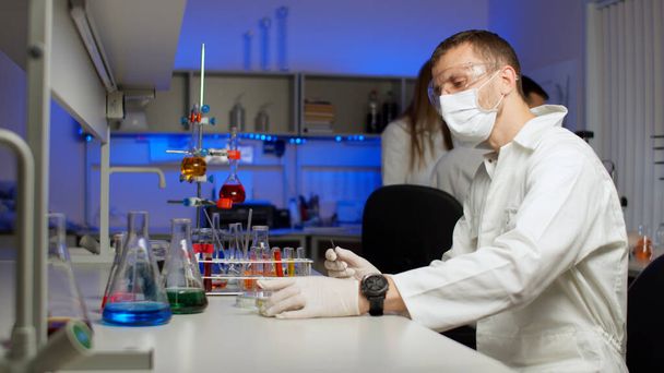 Jonge wetenschapper sorteert spruiten in petrischaal - Foto, afbeelding