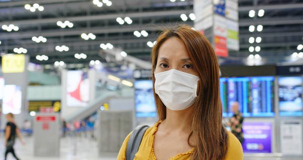 Kobieta nosić maskę medyczną na lotnisku - Zdjęcie, obraz