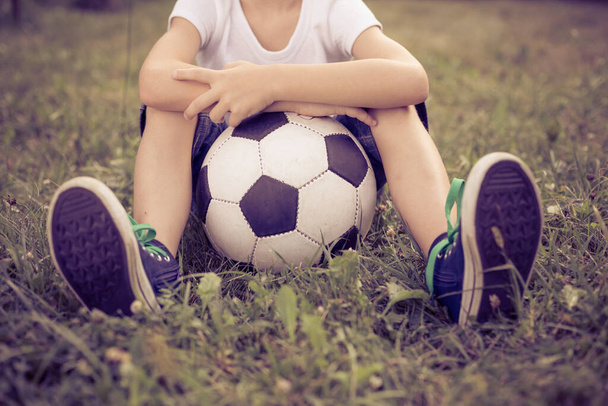 Young little boy sitting  with soccer ball. Concept of sport. - 写真・画像