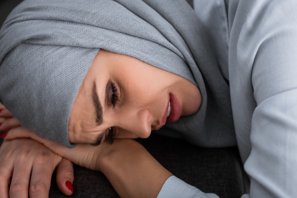 triste donna musulmana in hijab in salotto, concetto di violenza domestica
   - Foto, immagini