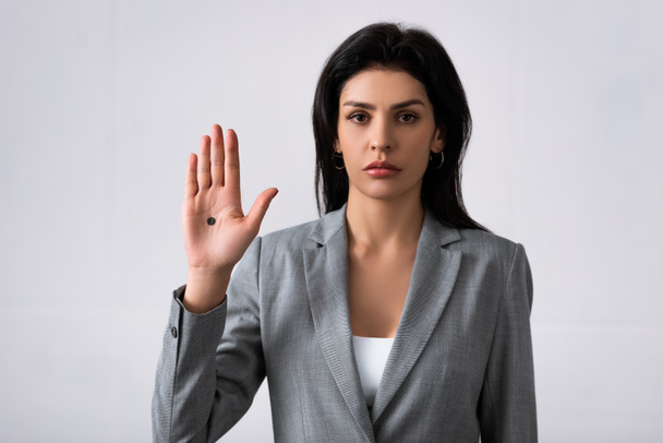 triste mujer de negocios mostrando la mano con el punto negro en la palma de la mano y de pie en blanco, concepto de violencia doméstica
  - Foto, Imagen