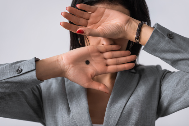 businesswoman with black dot on palm covering face isolated on white, domestic violence concept  - Φωτογραφία, εικόνα