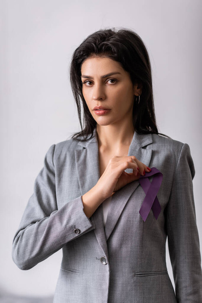 podnikatelka držící fialovou stuhu na šedé, domácí násilí koncept  - Fotografie, Obrázek