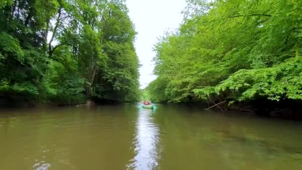 Pequeno barco de madeira navegando em um rio tropical selvagem na selva verde com uma mulher sentada na frente do barco
  - Filmagem, Vídeo