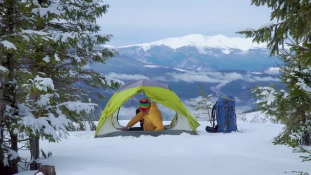 Turista relaxa em uma tenda nas montanhas no inverno
 - Filmagem, Vídeo