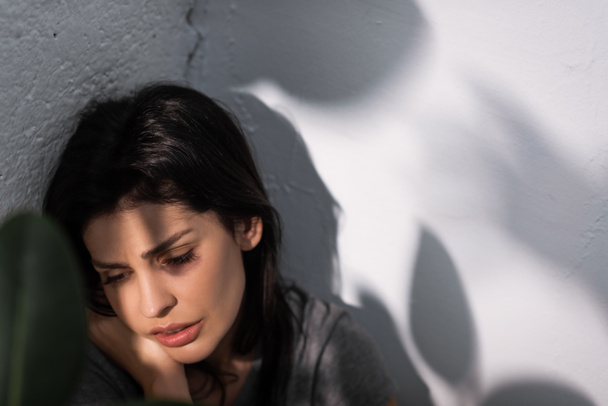 Yüzü morarmış depresif bir kadının seçici odak noktası, aile içi şiddet kavramı  - Fotoğraf, Görsel