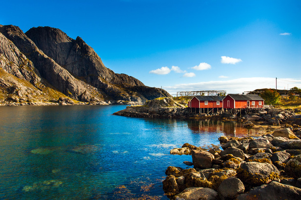 Cabanas de rorbu típicos vermelhos com telhado sod na cidade de Reine em ilhas Lofoten, na Noruega
 - Foto, Imagem