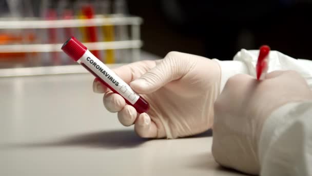 Scientist marking Coronavirus test tube - Кадри, відео