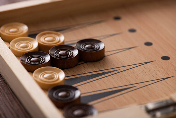 KYIV, UKRAINE - JANUARY 30, 2019: selective focus of wooden checkers on backgammon board - 写真・画像