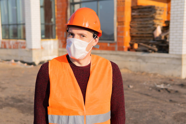 Portrait of male construction worker in medical mask and overalls - Foto, Imagem