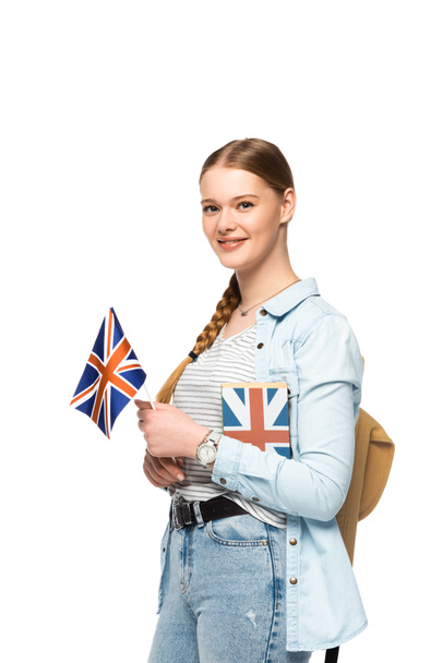Lächelnde hübsche Studentin mit Rucksack, Buch und britischer Flagge auf weißem Grund - Foto, Bild