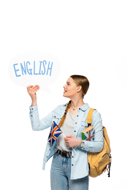 usmívající se hezká studentka s batohem drží knihu, hlasová bublina s anglickým písmem a britskou vlajkou izolované na bílém - Fotografie, Obrázek